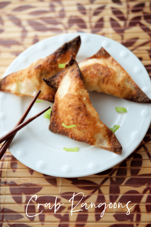 three crab rangoons on a white dish