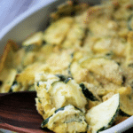 a close up of sliced zucchini in a casserole dish with parmesan cheese