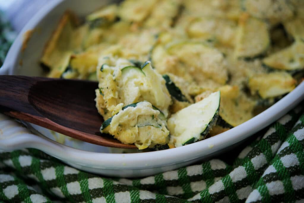 a close up of zucchini in a white dish on a spoon