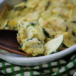 a close up of zucchini in a white dish on a spoon