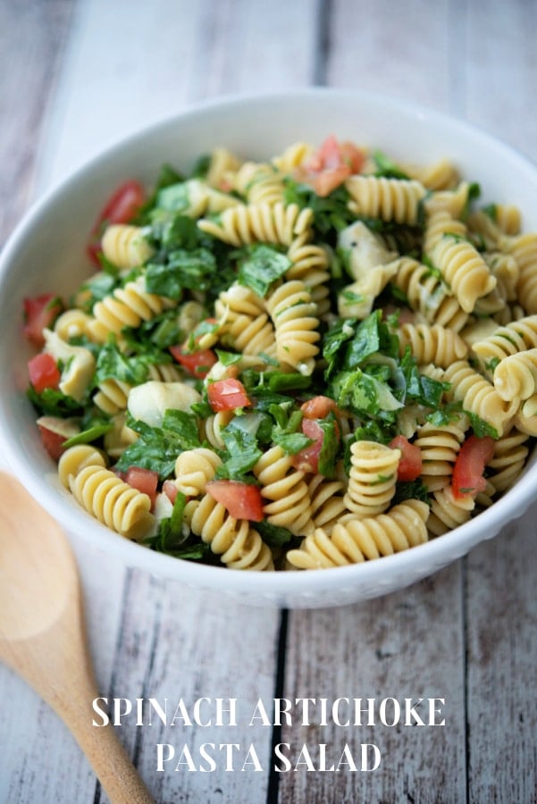 a bowl of spinach artichoke pasta salad