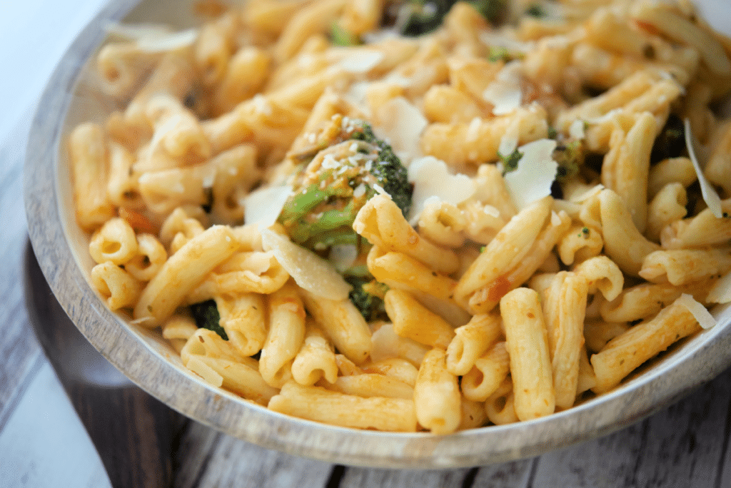 a close up of cavatelli with broccoli in a pink vodka sauce