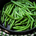 a close up of cooked green beans in a pan