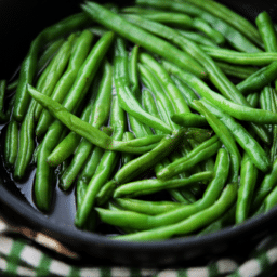 a close up of cooked green beans in a pan