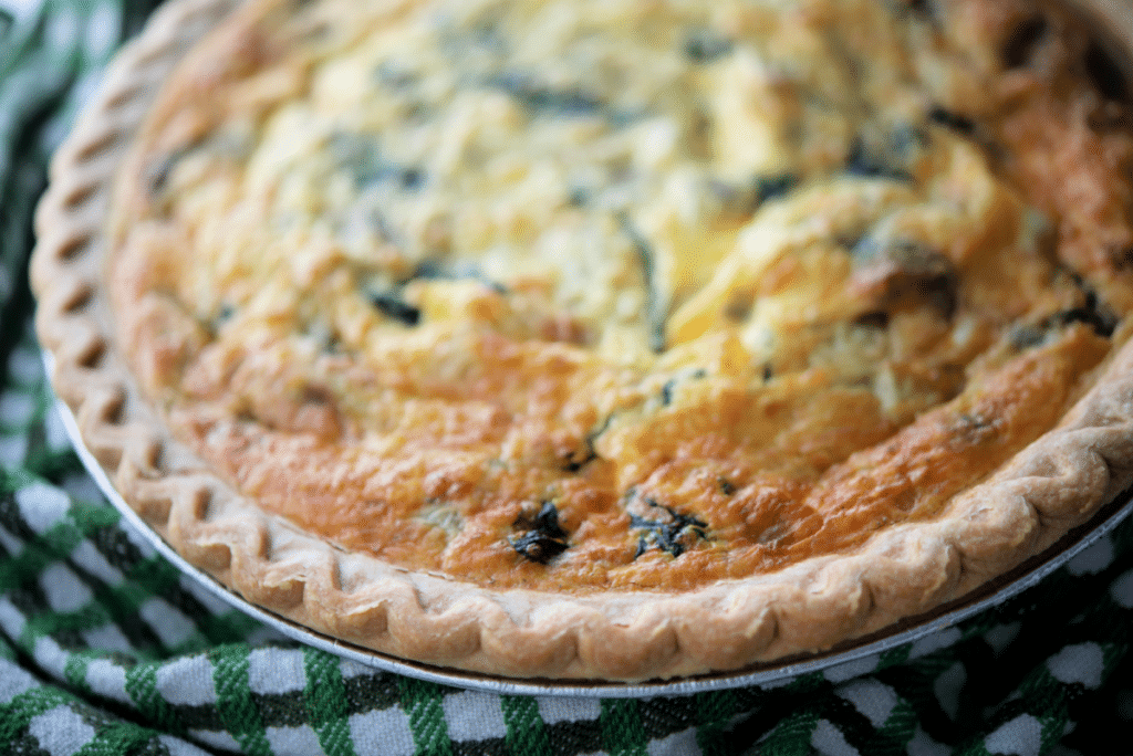 a close up of spinach artichoke quiche