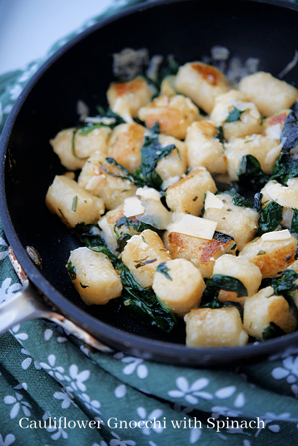a pan of cauliflower gnocchi with spinach