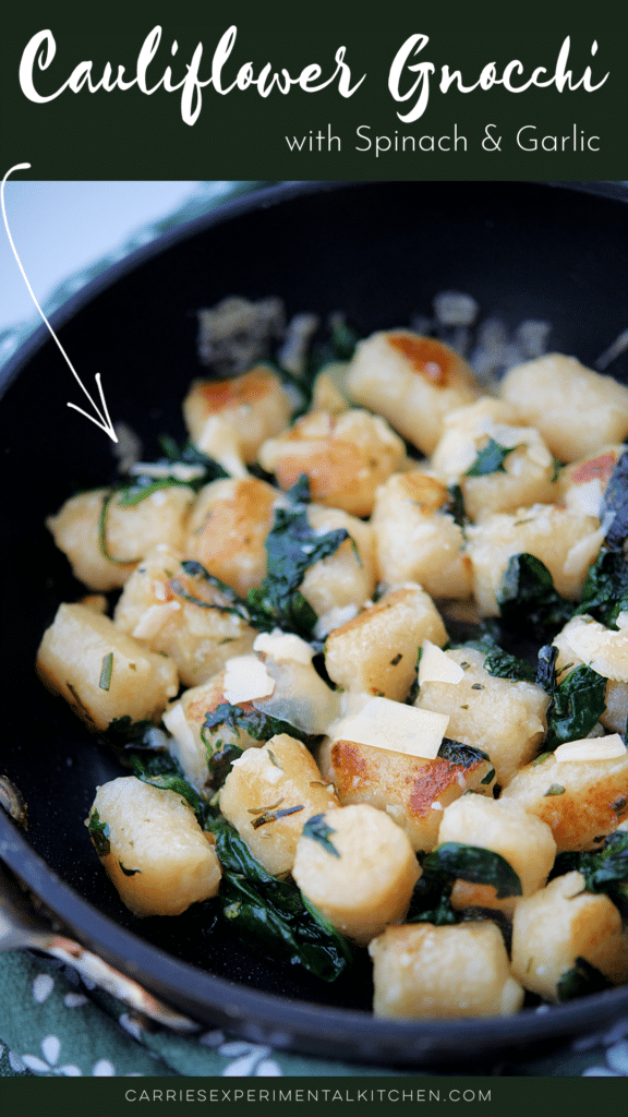 a skillet with cooked cauliflower gnocchi with spinach