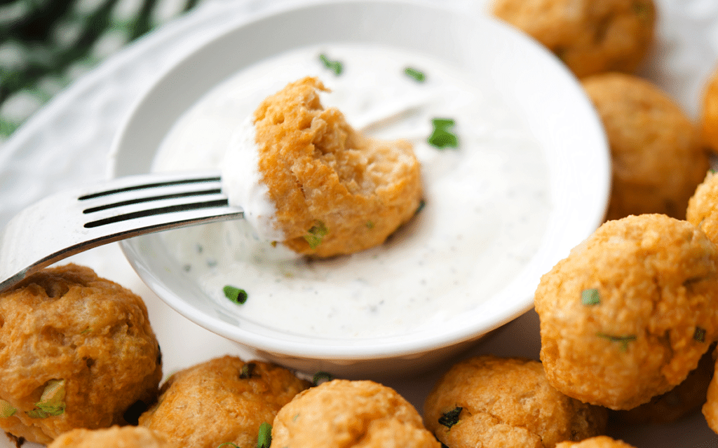 a buffalo chicken meatball on a fork with dip