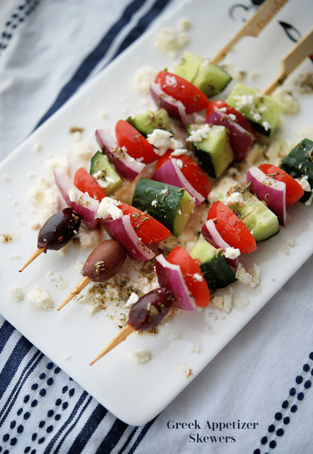 a plate of greek appetizer skewers