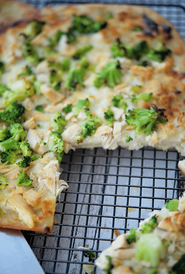 chicken broccoli flatbread with a piece cut out