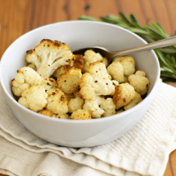 a bowl of roasted cauliflower with a spoon