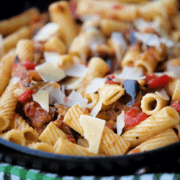 a close up of pasta in a skillet with eggplant sauce
