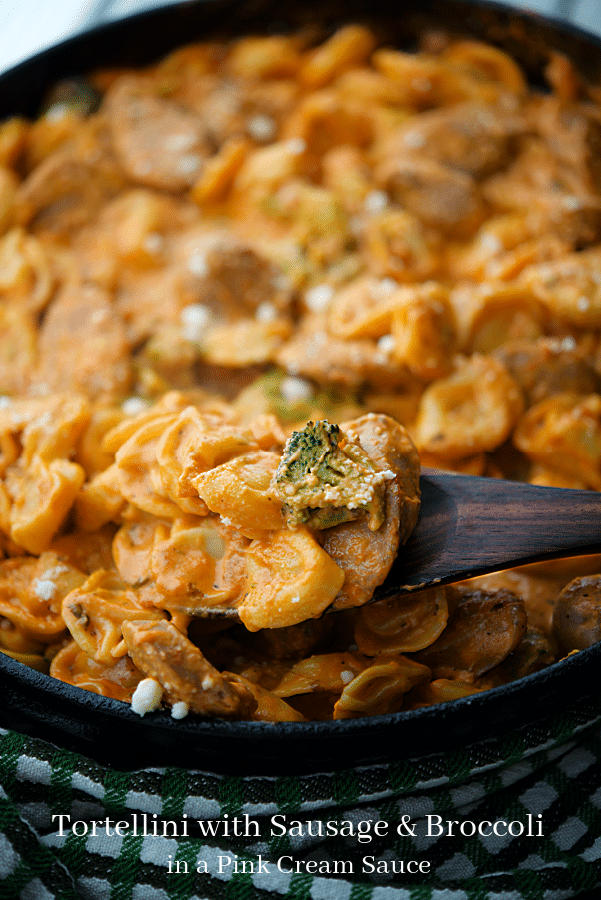 a pan with tortellini in a pink sauce