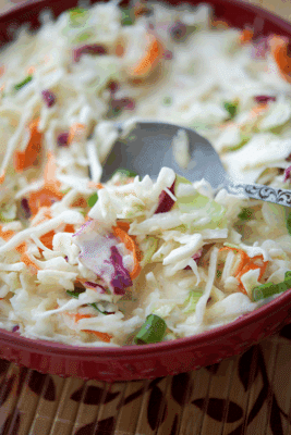 a spoon in a bowl of asian coleslaw