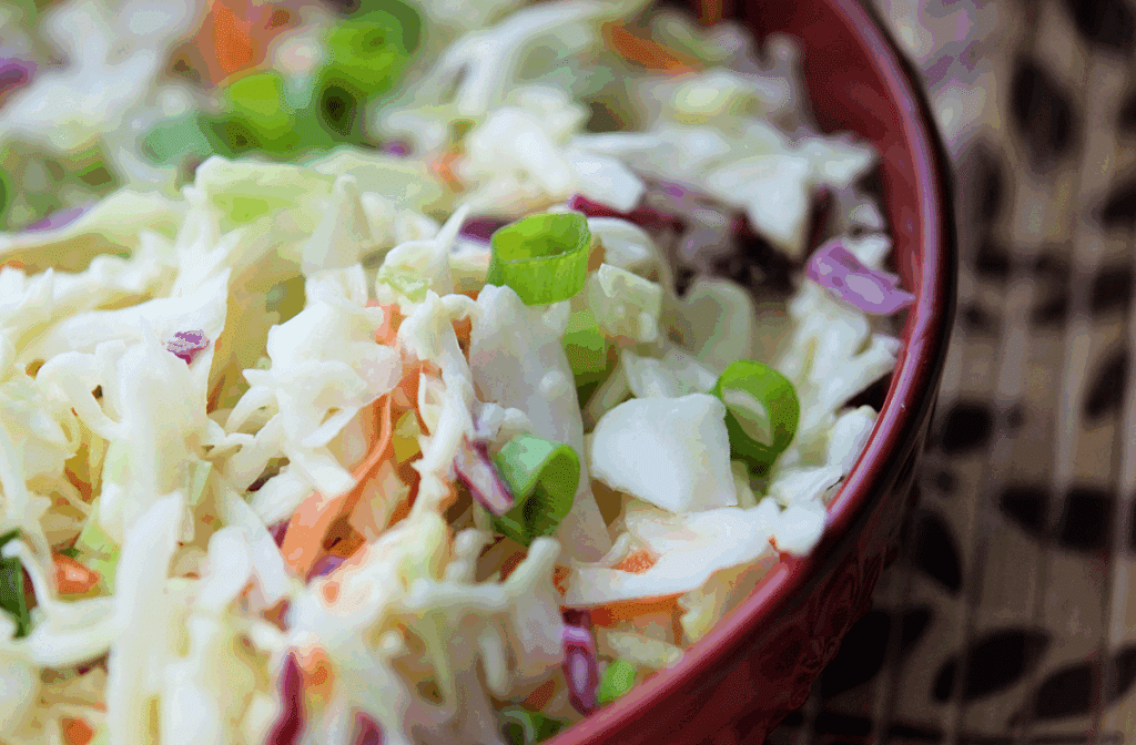 a closeup of asian coleslaw in a red bowl
