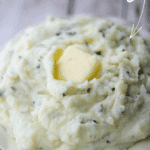 ricotta basil whipped potatoes in a bowl with melting butter
