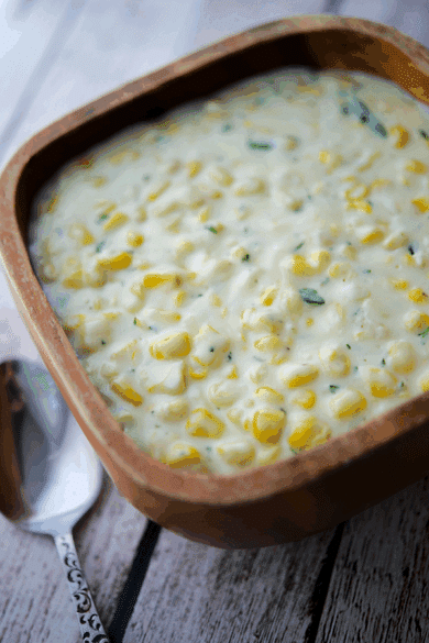 a wood bowl filled with rosemary creamed corn