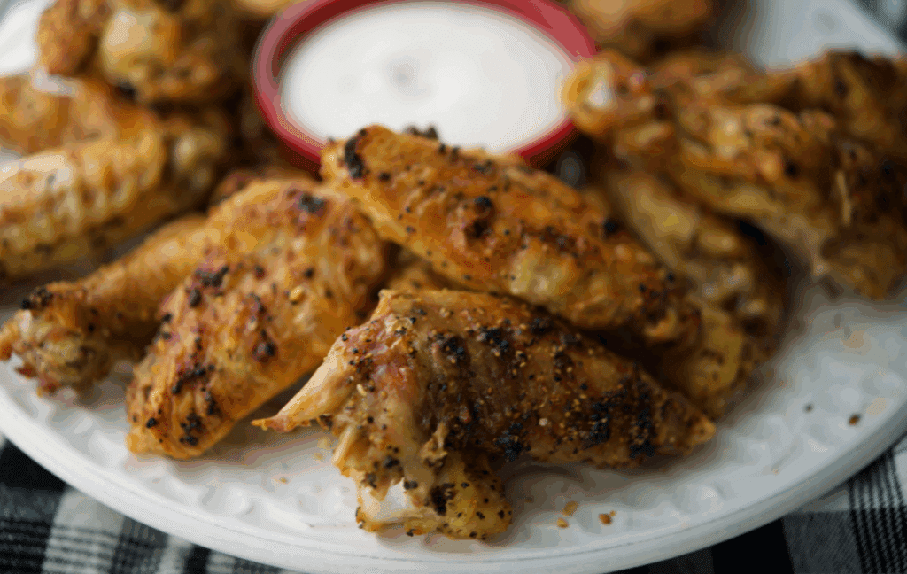 a close up of a plate of lemon pepper chicken wings